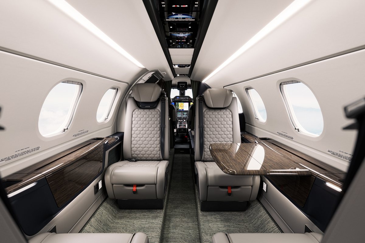 Light jet cabin with grey leather seats and wood trim