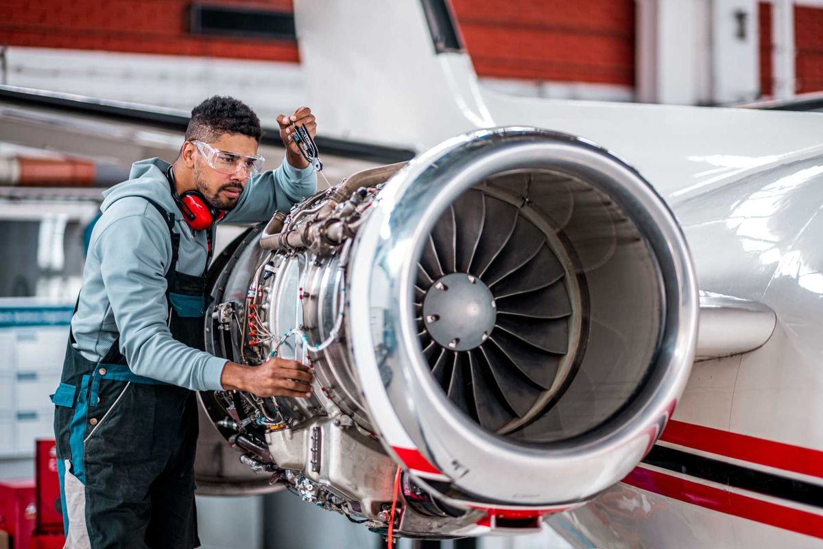 Aviation maintenance technician inspecting a jet engine